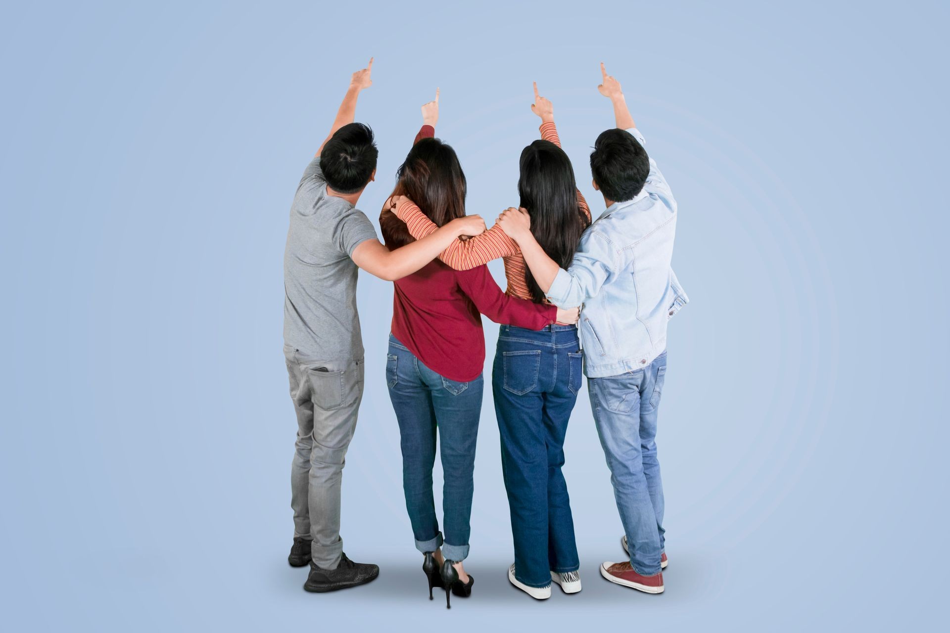 Rear view of four young people hugging each other while pointing something together in the studio